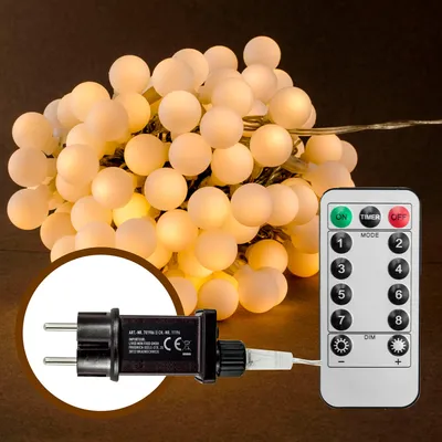 A string of white LED fairy lights with a remote control and power adapter.