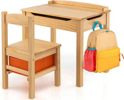 A wooden desk and chair set for children, with a backpack hanging from the desk.