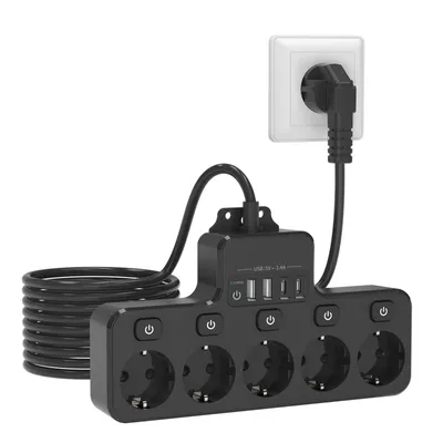 A black power strip with multiple outlets and USB ports is plugged into a white wall socket.