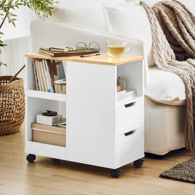 A white rolling cabinet with a wood-tone top sits next to a couch with a knitted blanket.