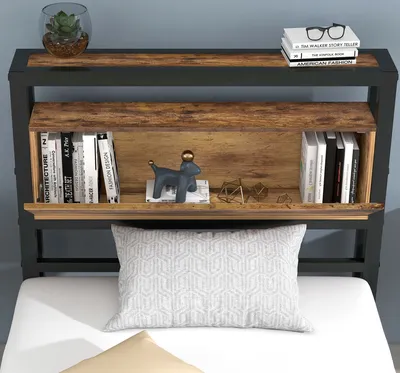 A close-up view of a metal bed frame's headboard with built-in shelving, displaying books and decorative items.