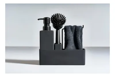 A black dishwashing set with a soap dispenser, brush, and towel in a holder.