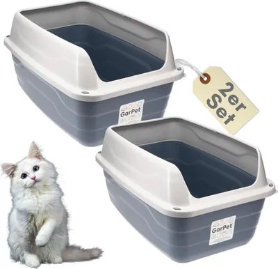 Two cat litter boxes are shown with a white cat in the foreground.