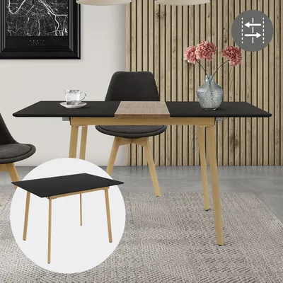A dining table set up in a dining room with chairs and a vase of flowers.