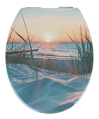 A toilet seat with a sunset beach scene printed on it.