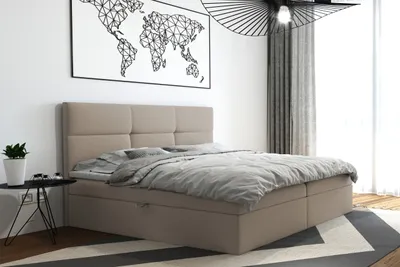 A bedroom scene with a beige boxspring bed, a world map poster on the wall, and a modern lamp.