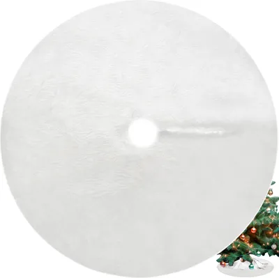 A white, circular Christmas tree skirt with a hole in the center, placed on a white background. A portion of a decorated Christmas tree is visible in the bottom right corner.