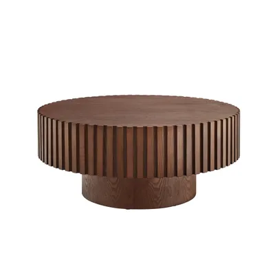 A round, wooden coffee table with a fluted base and top.