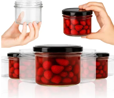 Hands holding jars of strawberries, with a row of jars in the background.
