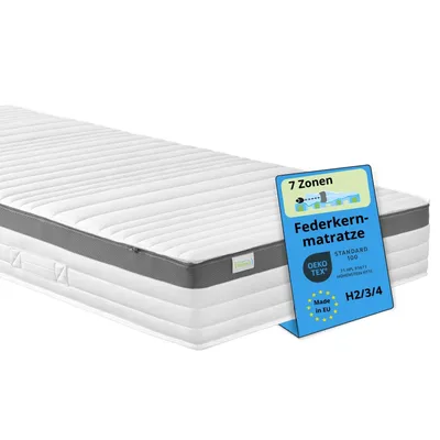A white mattress with a blue informational tag placed on its side.