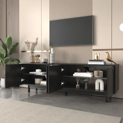 A modern living room scene featuring a black TV stand with open doors, displaying decorative items and books, with a large television mounted on the wall above it.