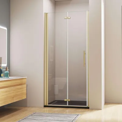 A modern bathroom with a wooden vanity and a gold-framed glass shower door.