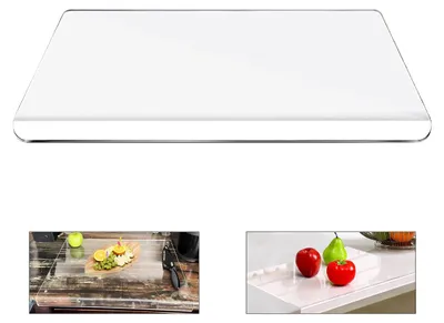 A clear, rectangular cutting board with rounded edges, shown from a slightly elevated angle.