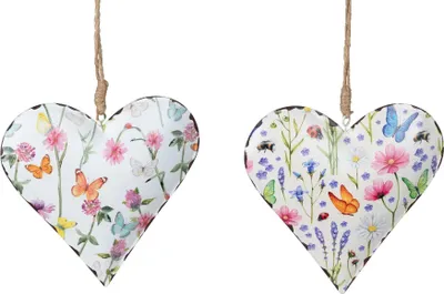 Two heart-shaped ornaments decorated with floral and insect motifs, hanging from twine.