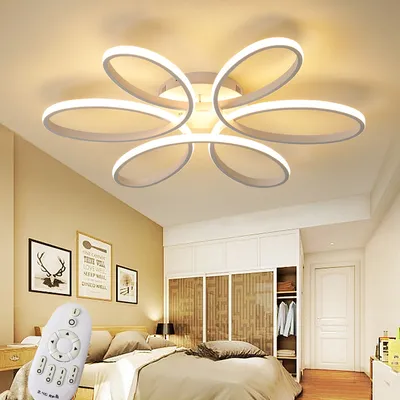 A bedroom with a modern ceiling light fixture and a bed.