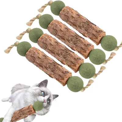 A set of four catnip sticks with green balls and rope, arranged diagonally on a white background. A cat is shown in the bottom left corner interacting with one of the sticks.