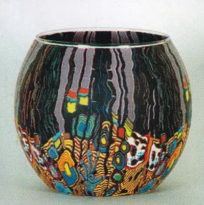 Ein Windlicht aus Fimo-Glas mit einem aufwendigen, farbenfrohen, abstrakten Design.