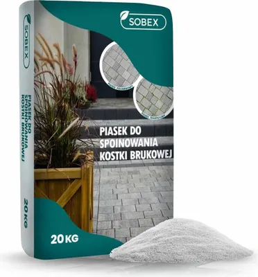 A bag of sand for paving stones with a pile of sand in front of it.