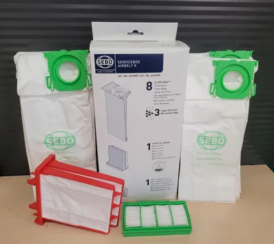 A collection of vacuum cleaner bags and filters, including a box of SEBO Servicebox Airbelt K filter bags.