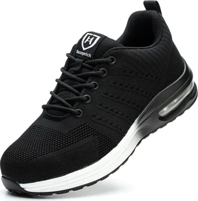 A black athletic shoe with white accents and a visible air cushion in the sole, presented on a white background.