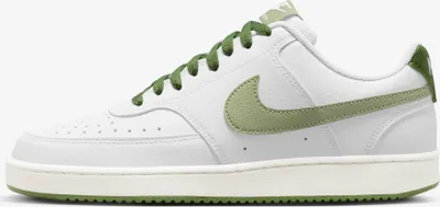 A side view of a white Nike Court Vision Low sneaker with green accents.