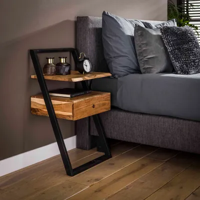 A bedside table next to a bed.