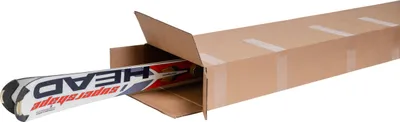 A pair of skis is partially inside a cardboard shipping box.