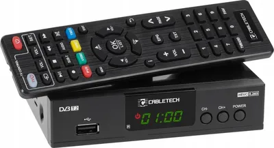 A black DVB-T2 tuner box with a remote control on top, set against a white background.