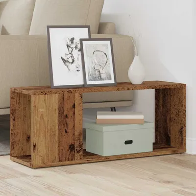 A wooden media console with framed artwork and decorative boxes.