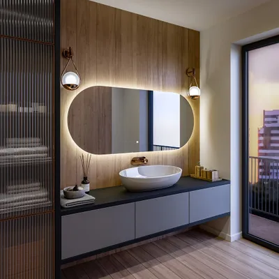 A modern bathroom vanity with a large oval mirror, sink, and storage cabinets.