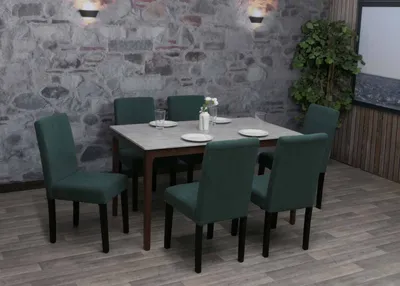 A dining set with chairs arranged around a table in a room with a stone wall and wooden floor.