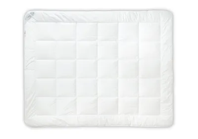 A white quilted comforter or duvet laid flat on a white background.