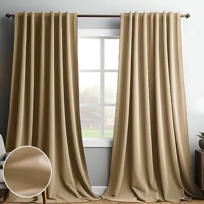 Two beige curtains hanging in front of a window.