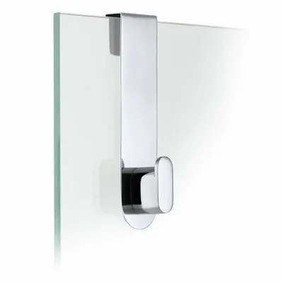 A chrome hook hangs on a glass surface.