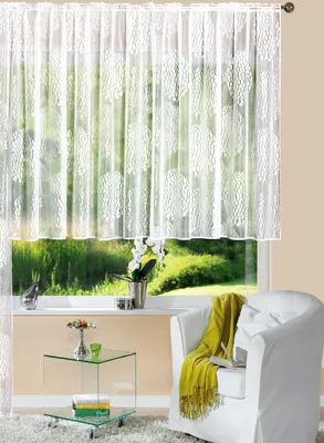 A living room scene with a window covered by a white sheer curtain, a white armchair with a yellow throw, and a glass side table.