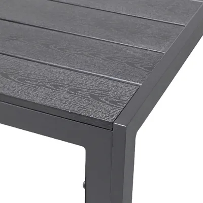 Close-up of the corner of a dark gray outdoor table with a slatted top.