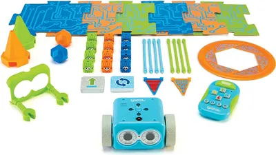 A collection of educational coding toys for children, including a robot, puzzle pieces, cones, and a remote control, laid out on a white background.