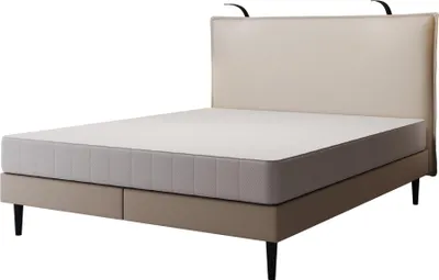 A bed with a mattress and headboard, shown from a side-angle.