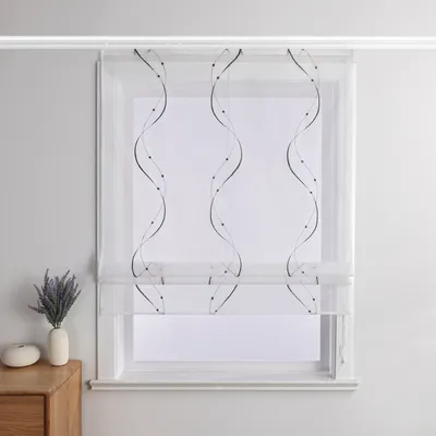 A white sheer Roman blind with a gray wavy beaded pattern is displayed in a window.