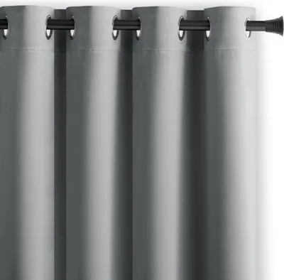 A close-up view of several gray curtains hanging on a rod.