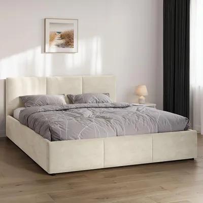A beige upholstered bed with a headboard and storage drawers, set in a bedroom with a framed picture on the wall and dark curtains.