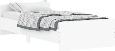 A white bed frame with a white mattress and a grey and white patterned blanket.