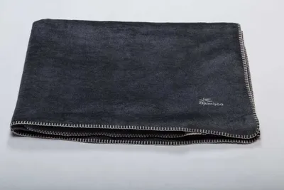 A folded dark gray blanket is shown on a light gray background.