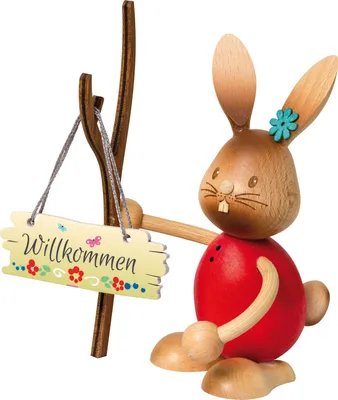 A wooden Easter bunny decoration holding a welcome sign.