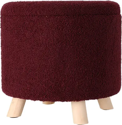 A burgundy round ottoman with wooden legs on a white background.