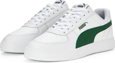 A pair of white Puma sneakers with green accents.