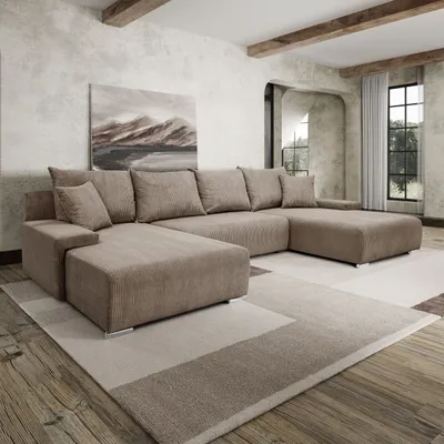 A spacious living room with a large U-shaped sofa, a painting on the wall, and wooden beams on the ceiling.