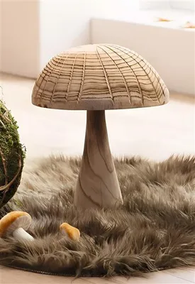 A large wooden mushroom decoration sits on a furry rug, with smaller mushroom decorations and a moss ball nearby.
