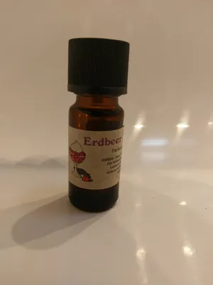 Kleine braune Flasche mit einem schwarzen Verschluss. Auf dem Etikett steht "Erdbeer Sahne".