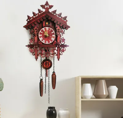 A vintage-style cuckoo clock is mounted on a white wall, with a wooden shelf and decorative vases visible in the lower right corner.